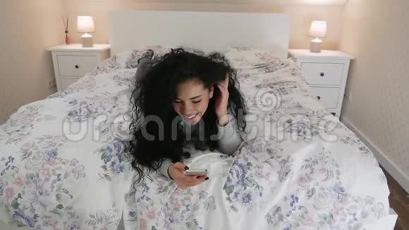 年轻可爱的女人用手机盯着下巴视频的预览图