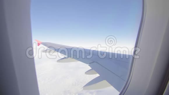 飞机飞行飞行在云层之上的飞机的机翼从平面的窗口查看飞机旅行视频的预览图
