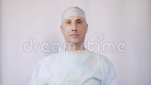 一位白人医生在手术前戴上医疗面罩他对病人的态度是积极的视频的预览图