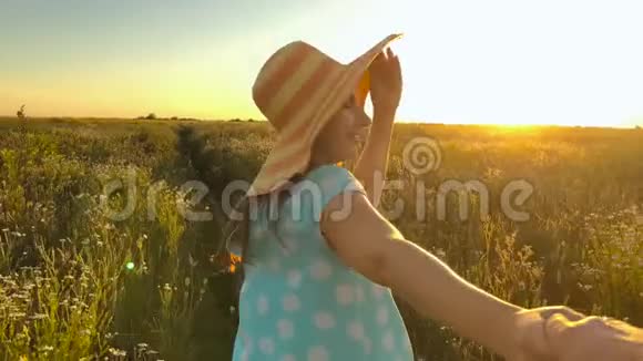 跟着我快乐的年轻女人戴着黄色帽子拉着男人手手牵手走着把一片绿色的麦子扔向视频的预览图