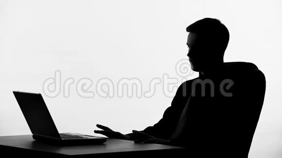 商务人士坐在笔记本电脑前的剪影思考商业提案视频的预览图
