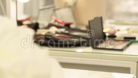 化妆室化妆用的化妆品工具和刷子躺在化妆室的桌子前镜子上视频的预览图