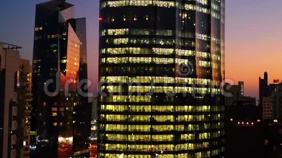 日落时分闪烁的摩天大楼窗户现代办公室和塔楼的景色视频的预览图