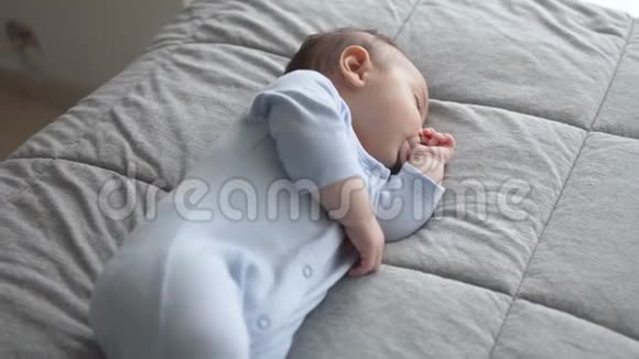 可爱的小男孩用手指在嘴里睡觉视频的预览图