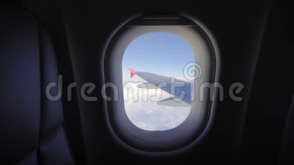 飞机飞行飞行在云层之上的飞机的机翼从平面的窗口查看飞机旅行视频的预览图