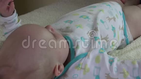 按摩师在特殊的桌子上给5个月的婴儿做腿部按摩4K视频的预览图
