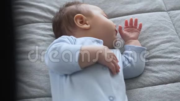 可爱的小男孩用手指在嘴里睡觉视频的预览图