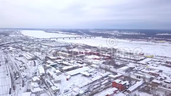 鸟瞰冰冻河流冬季景观削减冬季河流结冰的城市俯瞰图视频的预览图