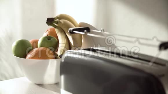 早餐在烤面包机特写镜头中放切面包的女人视频的预览图