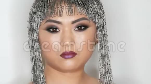 高级时尚一位美丽的亚洲女孩模特的肖像有着明亮的妆容和不寻常的文具夹假发视频的预览图