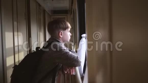 这个男孩站在火车窗口看着窗外的风景坐火车旅行旅游业视频的预览图