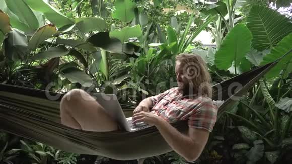 氪货币交易员躺在吊床上用笔记本电脑做交易视频的预览图