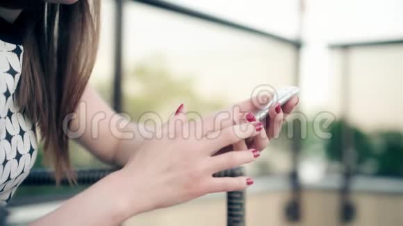红发女性手握智能手机的特写镜头在触摸屏上输入文本女回复朋友留言视频的预览图