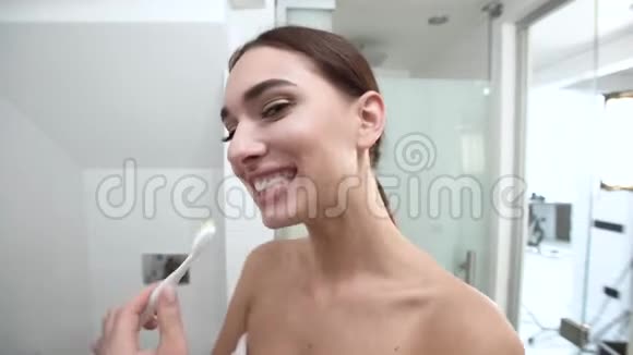 牙齿卫生女人刷牙看镜头视频的预览图