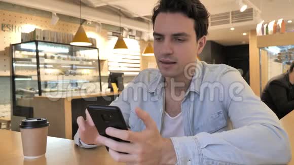 年轻人在咖啡厅智能手机上的在线视频聊天视频的预览图
