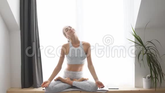 在家做瑜伽和听音乐的女人视频的预览图