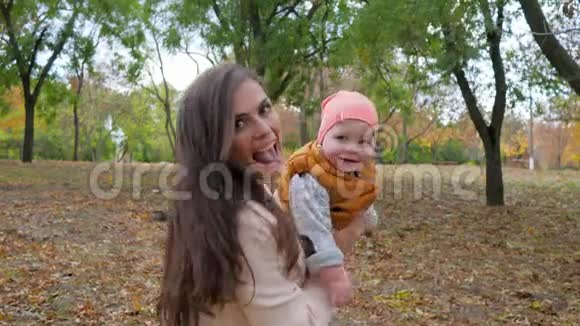 快乐的家庭享受大自然年轻的妈妈和宝宝在秋天的公园户外玩得开心视频的预览图