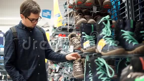 男人惊讶地看着一双男鞋在商店里散步视频的预览图