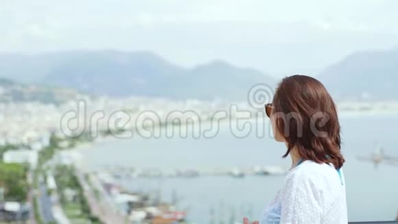 一位女游客欣赏美丽的风景从高处俯瞰城市视频的预览图