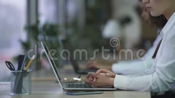 严肃的女办公室职员双手交叉坐着厌倦了无聊的工作视频的预览图
