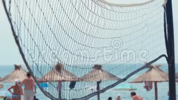 地球场上的排球网在烈日下近距离射击海滩上美丽的照片视频的预览图