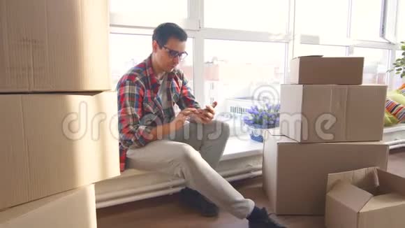 1年轻人常打电话坐在新公寓里视频的预览图