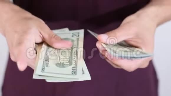 一个人在一捆中数出一百美元的钞票美元纸币视频的预览图