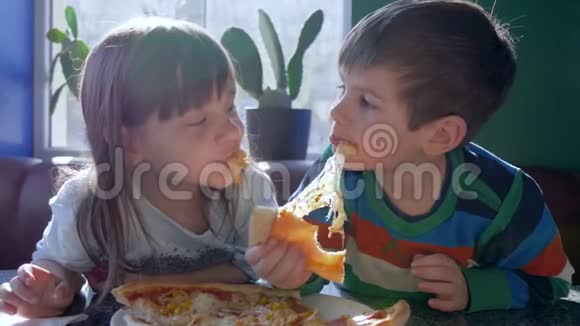 不健康的食物可爱的孩子在窗户附近的餐馆午餐时吃开胃的食物视频的预览图