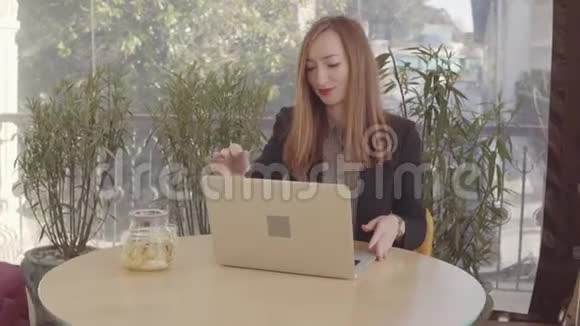 一个有茶和笔记本电脑的咖啡馆里的商务女士视频的预览图