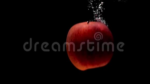 两个红苹果落在黑底透明的水里视频的预览图