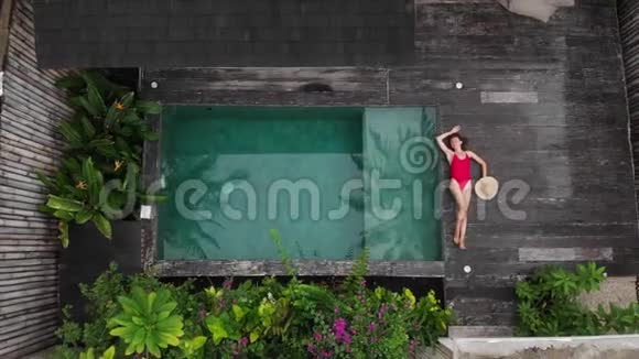 鸟瞰年轻女子穿着黑色比基尼躺在沙滩上白沙起泡的印度洋海浪巴厘岛视频的预览图