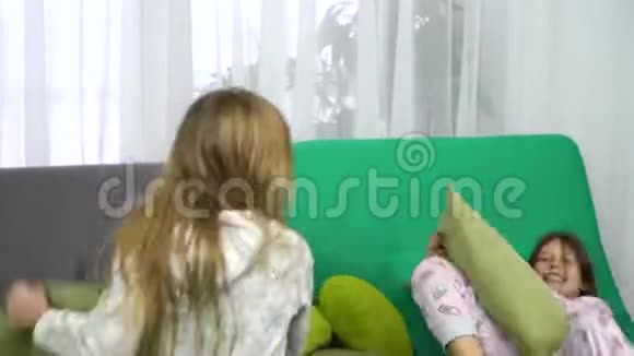 两个小女孩在沙发上抱着枕头打架视频的预览图