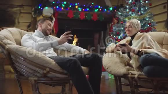 男人在圣诞夜向女人展示他的智能手机屏幕视频的预览图