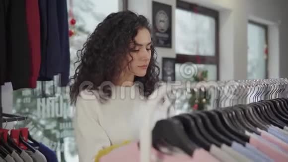 迷人的年轻女子在精品店购物视频的预览图