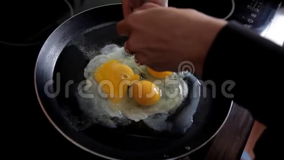 早上女孩在家里厨房准备早餐在煎锅里打碎鸡蛋特写镜头煮鸡蛋视频的预览图