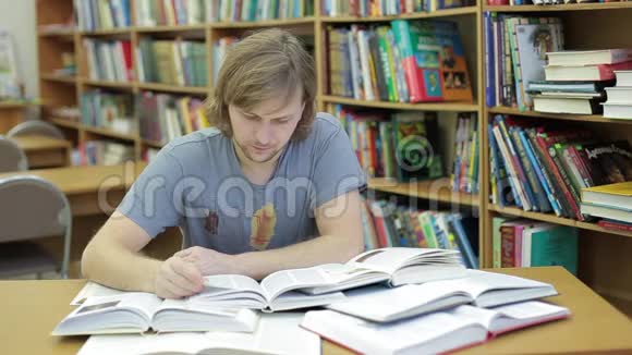 图书馆里的一个年轻人读了很多书他被大量的信息吓坏了学生读物视频的预览图