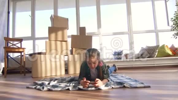 1011岁的女孩他在盒子的背景上使用智能手机视频的预览图