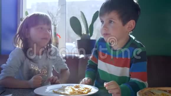 孩子们的食物小家伙们从一个盘子里吃午餐坐在咖啡馆的桌子上视频的预览图