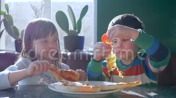 晚餐时吃披萨好孩子在度假时坐在餐桌上吃美味的食物视频的预览图