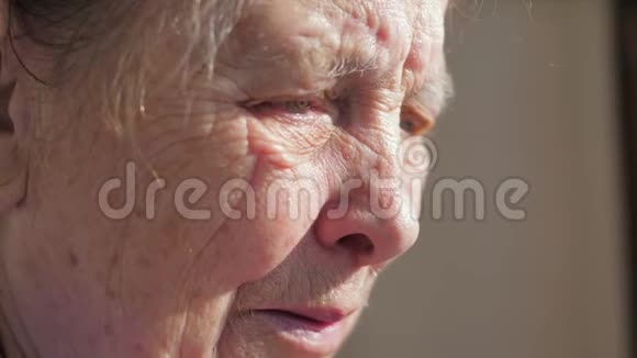 老年妇女颤抖眼睑悲伤面容的特写视频的预览图