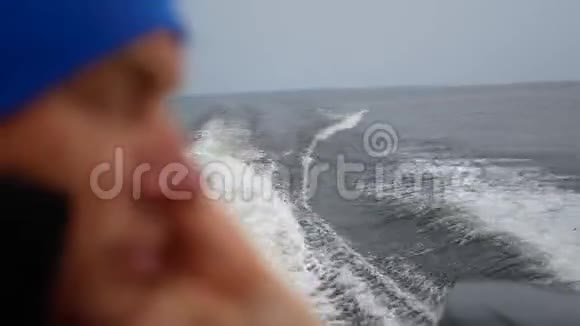 亮蓝帽快速海上浮舟的特写模糊脸人视频的预览图