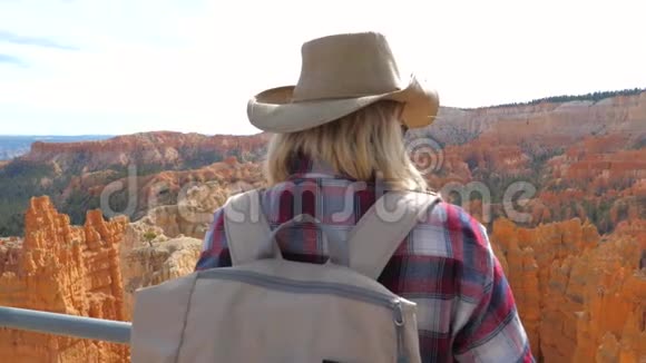 积极的女性游客站在观景台俯瞰峡谷4K视频的预览图