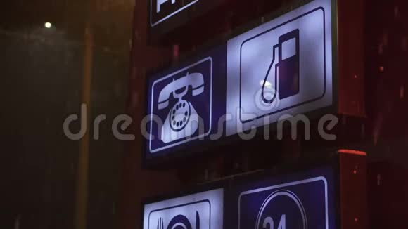 在加油站的红灯下雪花在夜间飘落上面有煤气食品电话和24小时图标视频的预览图