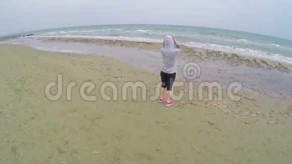 布鲁内特女孩站在海滩上享受凉爽的海景放松视频的预览图