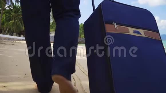 穿西装的商人带着一个手提箱沿着美丽的大海的海岸散步自由职业概念期待已久的休闲视频的预览图