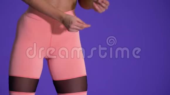 穿着粉色瑜伽裤跳舞的年轻健康女子视频的预览图