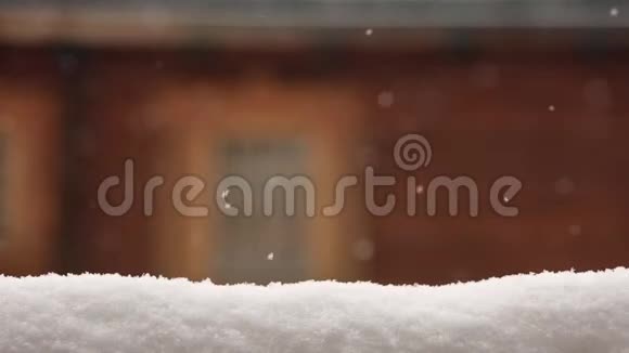 雪覆盖面进行产品摆放背景上有窗户的模糊木屋墙大雪纷飞视频的预览图