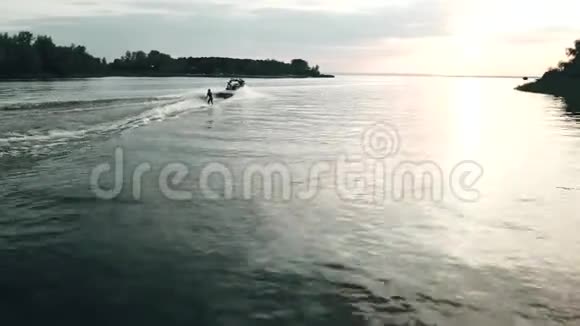 镜头跟在唤醒者冲浪后面日落时的空中观光视频的预览图