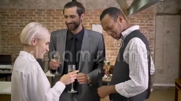 三个不同种族的工人在办公室跳舞喝香槟参加公司聚会视频的预览图