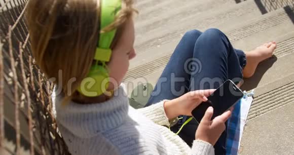在海滩附近使用手机的女孩视频的预览图